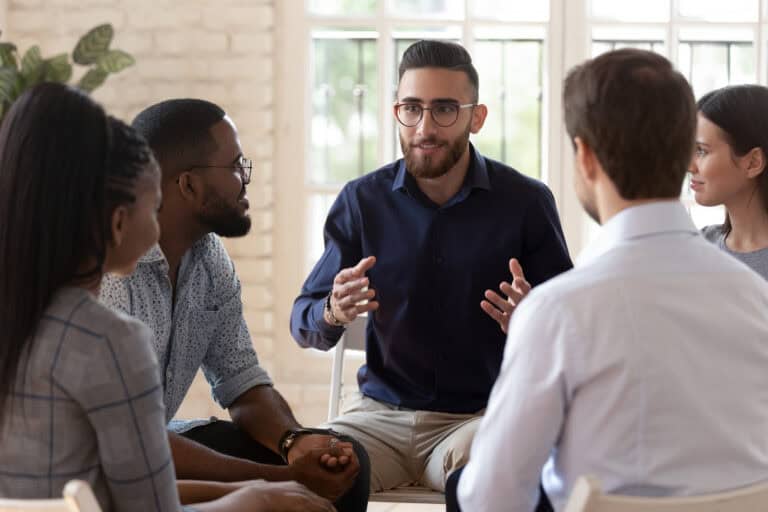 Multiethnic young people talk at psychological group training